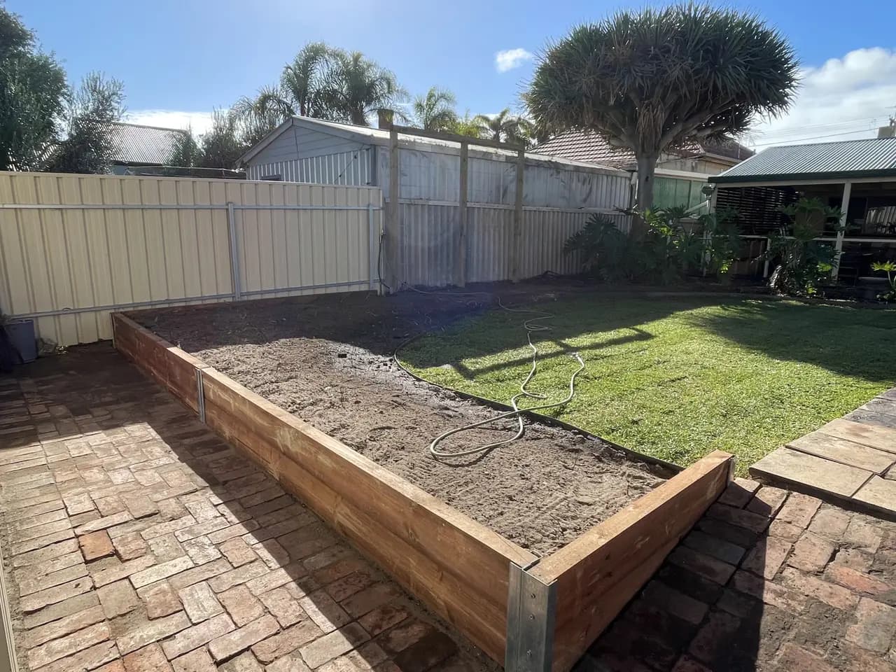 A timber sleeper retaining wall on galvanised steel posts holding a raised garden bed in Adelaide